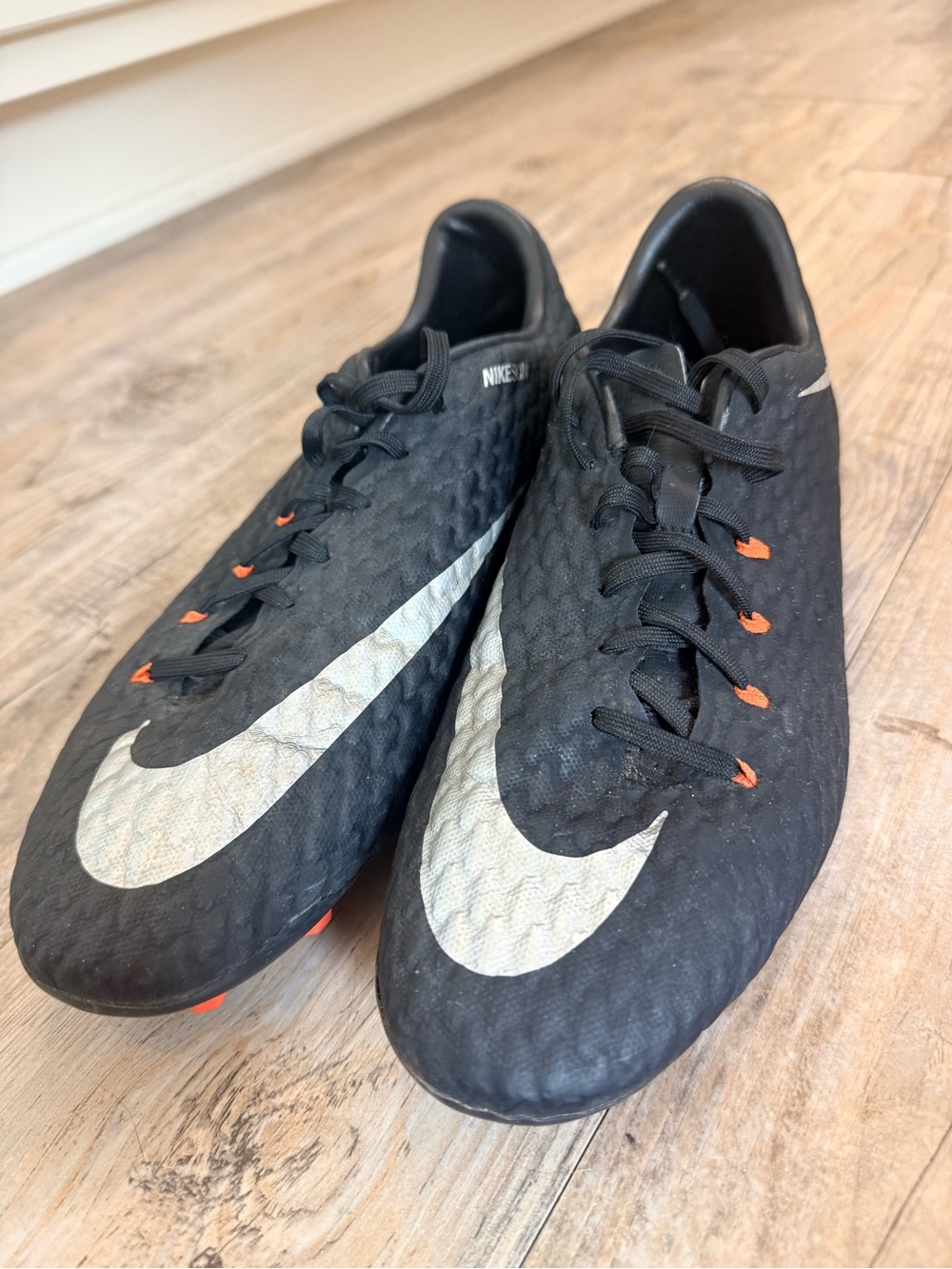 Nike Men's Black Soccer Cleats with Silver Swoosh and Orange Accents